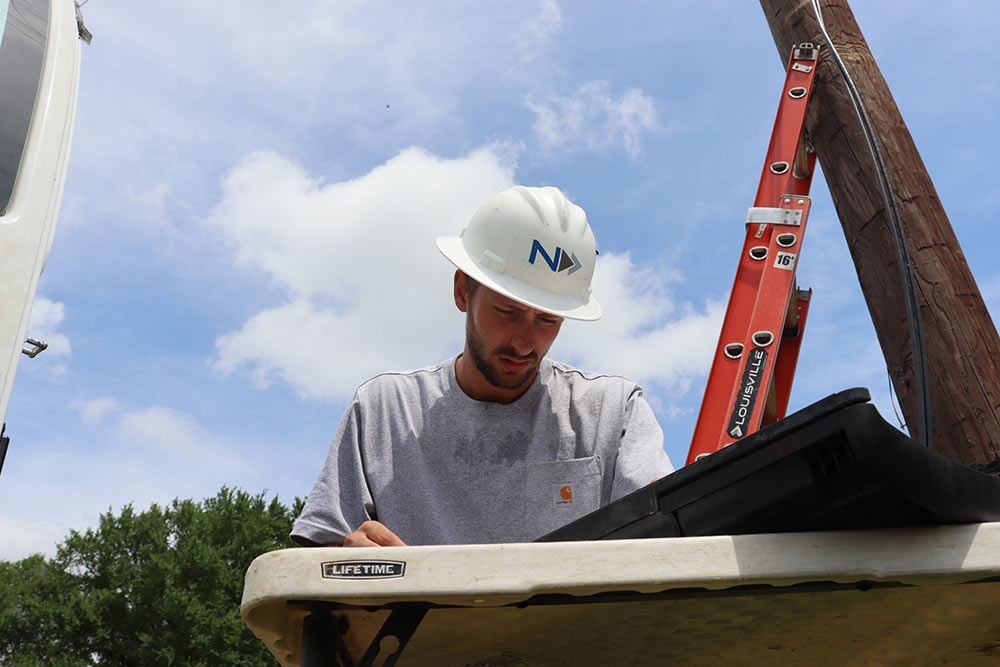 James Moore, fiber splicing technician with National OnDemand marking a tap after splicing in a 12-count fiber cable.